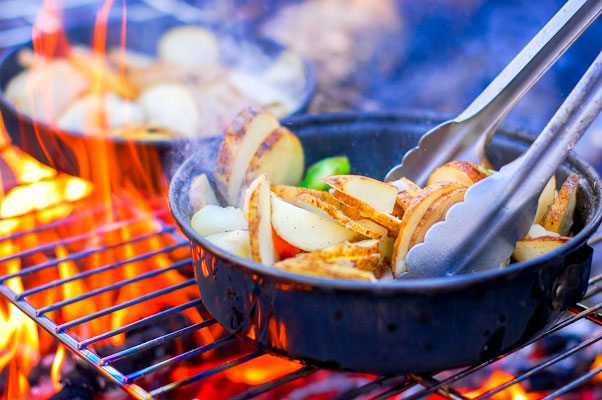 Pans cooking over open flames at the Culinary Institute
